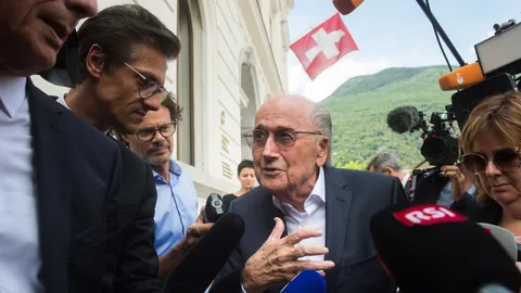 Blatter umgeben von Medienschaffenden vor dem Bundesstrafgericht, erklärt sich gestikulierend..