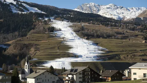 Beschneite Piste umgeben von Rasen