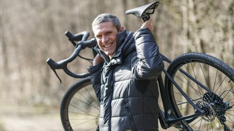 Auf dem Bild ist Andy Kessler mit einem Gravelbike zu sehen.