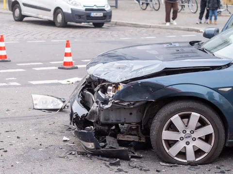 Auto mit beschädigter Front nach Unfall auf der Strasse.