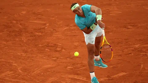 Tennisspieler schlägt auf einem Sandplatz auf.