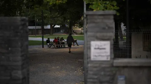 Menschen im Park sitzen an einem Tisch.