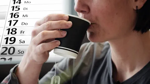 Frau mit Becher vor Kalender