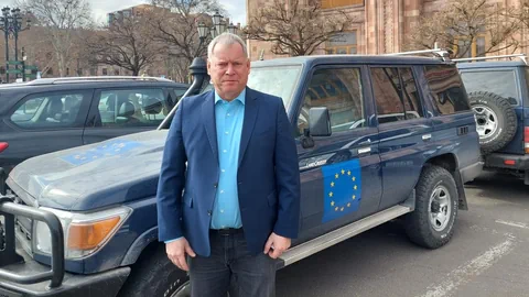 Markus Ritter lehnt sich an einem Geländewagen der EU-Mission an und schaut in die Kamera