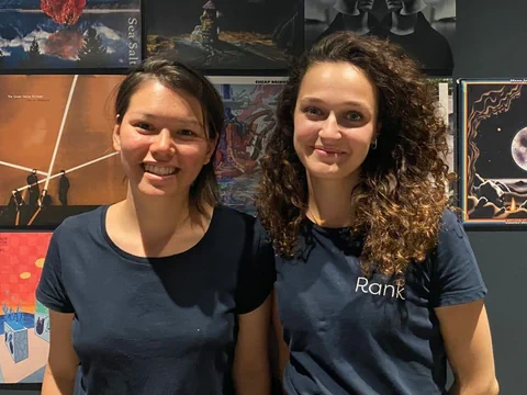 Zwei Frauen (Michaela und Nicole) stehen nebeneinander. Sie tragen beide schwarz und lächeln in die Kamera.