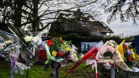 Blumensträusse hängen an Zaun vor dem abgebrannten Familienhaus