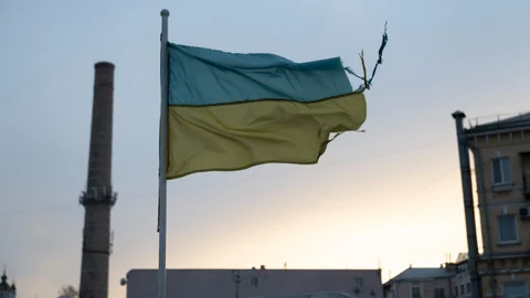 Ukraine-Flagge weht im Wind vor Sonnenuntergang.