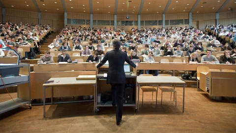 Ein Professor steht vor einer Schulklasse