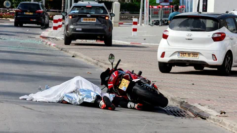 Ermordeter Motorradfahrer liegt zugedeckt neben seiner Maschine am Boden.