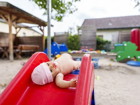 Puppe auf einer Rutschbahn auf einem Spielplatz