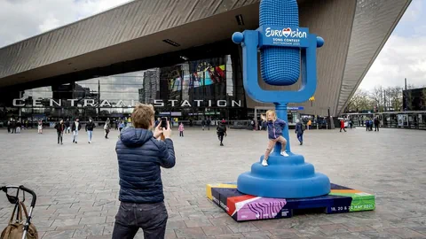 Mann mancht Foto von Kind vor grossem blauen Mikrofpn vor Festhalle.