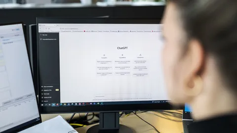 Person betrachtet ChatGPT-Webseite auf einem Computerbildschirm.