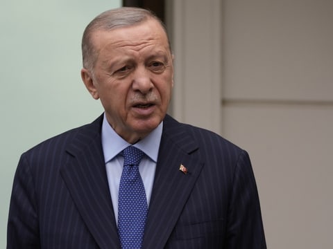 Recep Tayyip Erdoğan steht im Anzug vor einem Gebäude