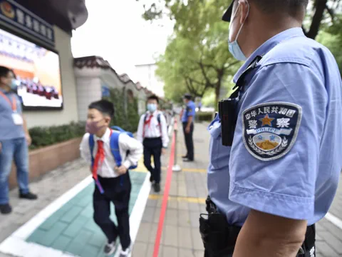 Polizist bewacht Eingang zu Schule.