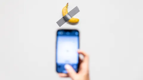 eine banane klebt an einer Wand und wird fotografiert.