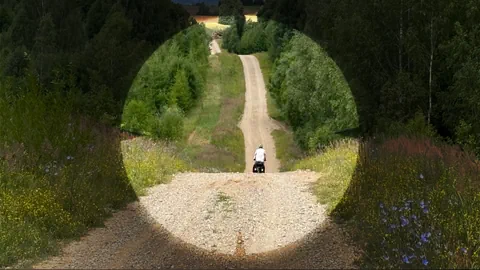 Velofahrer in idyllischer Landschaft umrahmt von einem Sucher