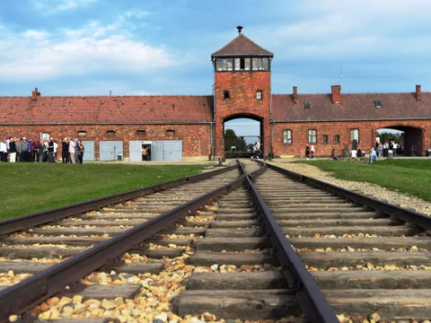 Einfahrtstor mit Schienen in Auschwitz-Birkenau.