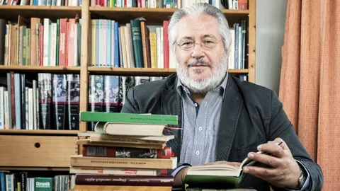 Professor Huonker am Schreibtisch mit Büchern.