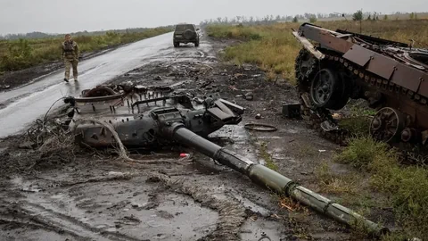 Zerstörter Panzer an einer Strasse.