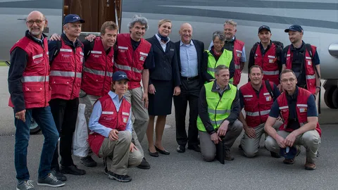 Das Helferteam vor einem Flugzeug