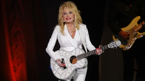 Dolly Parton mit Gitarre.