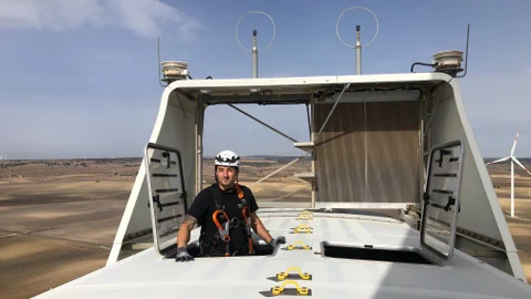 Techniker auf einer BKW-Windkraftanlage in der Landschaft.