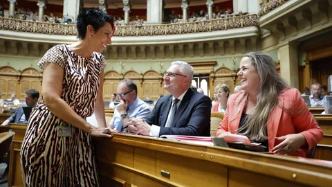 Politikerinnen und Politiker lachen im Parlament.