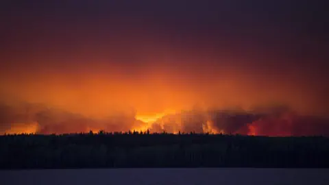 Waldbrand am Horizont bei Sonnenuntergang.