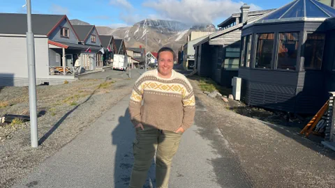 Celine Andreassen blickt in die Kamera und steht auf einer Strasse in Longyearbyen.