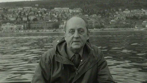 Schwarzweiss-Bild von Archibald Quartier auf einem Boot auf dem See.