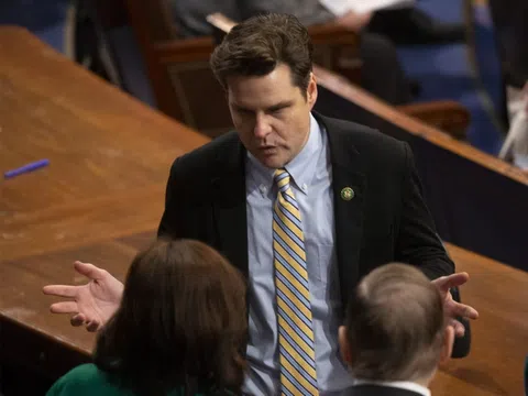 Matt Gaetz im Anzug spricht mit zwei Leuten im US-Kongress.