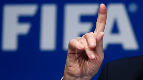 Hand mit ausgestrecktem Zeigefinger vor Fifa-Logo