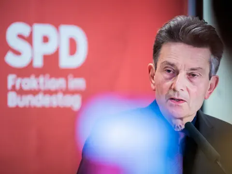 Mann spricht vor SPD-Banner.