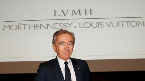 Der reichste Mann der Welt, Bernard Arnault, vor einem Schild seines Konzerns LVMH