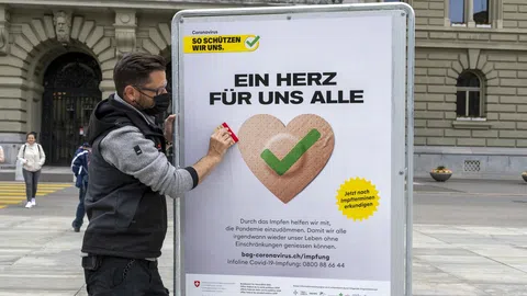 Person streicht ein Plakat zurecht.