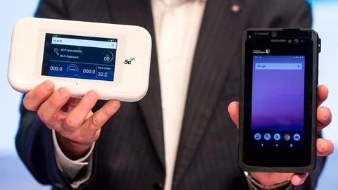 Ein Vertreter der Swisscom zeigt den Prototypen eines 5G-fähigen Smartphones von Qualcomm (rechts).