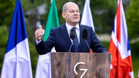 Bundeskanzler Olaf Scholz am Mikrofon beim G7-Gipfel.