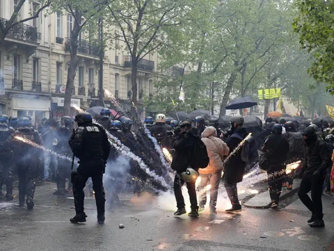 Ein Feuerwerkskörper explodiert zwischen Polizisten und Demonstranten.