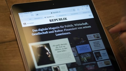 Eine Person konsultiert das Online-Magazin Republik auf einem Tablet.