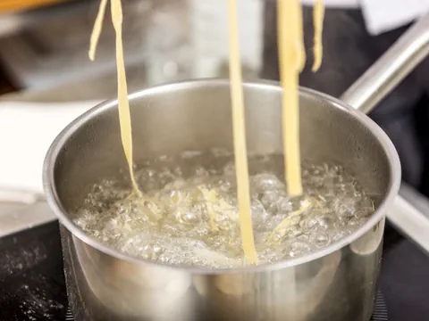 Nudeln kochen in einem Topf mit kochendem Wasser.