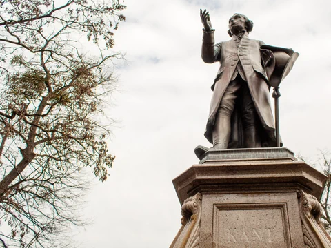 Eine Bronzestatue eines Mannes. Auf dem Sockel steht «Kant»