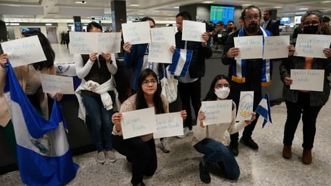 Leute mit Namensschildern an einem Flughafen.