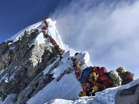 Bergsteigerkolonne auf schneebedecktem Berggrat.