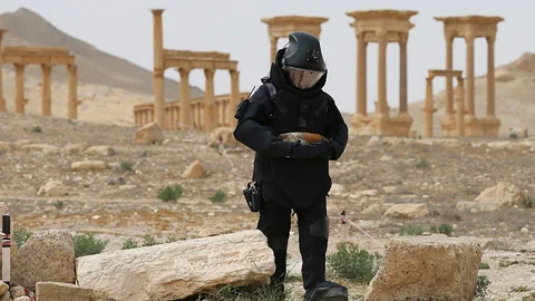 Mann in schwarzer Uniform vor Tempel.