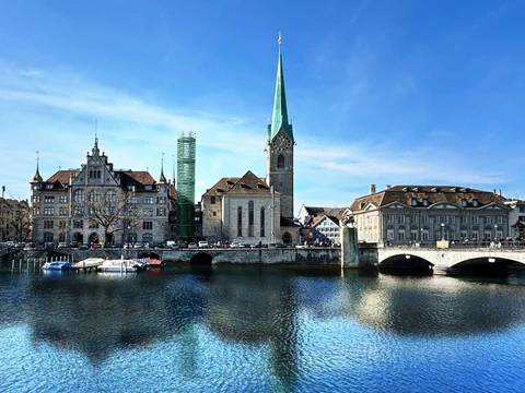 Stadtansicht mit Fraumünsterkirche in Zürich und Fluss.