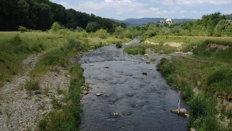 Back mit natürlichem Bachbett, im Hintergrund Schloss Wildegg