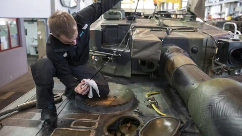 Ein Mechaniker arbeitet an einem Panzer.