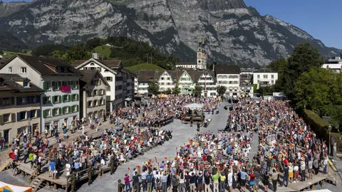 Glarnerinnen und Glarner stehen im Ring auf dem Landsgemeindeplatz und stimmen ab. 