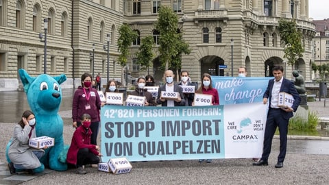 Motionäre mit Maskottchen vor Transparent