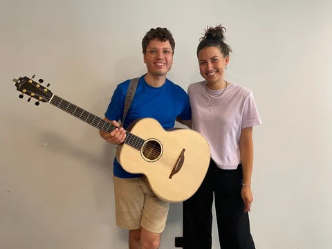 Ein Mann mit Gitarre steht neben einer Frau